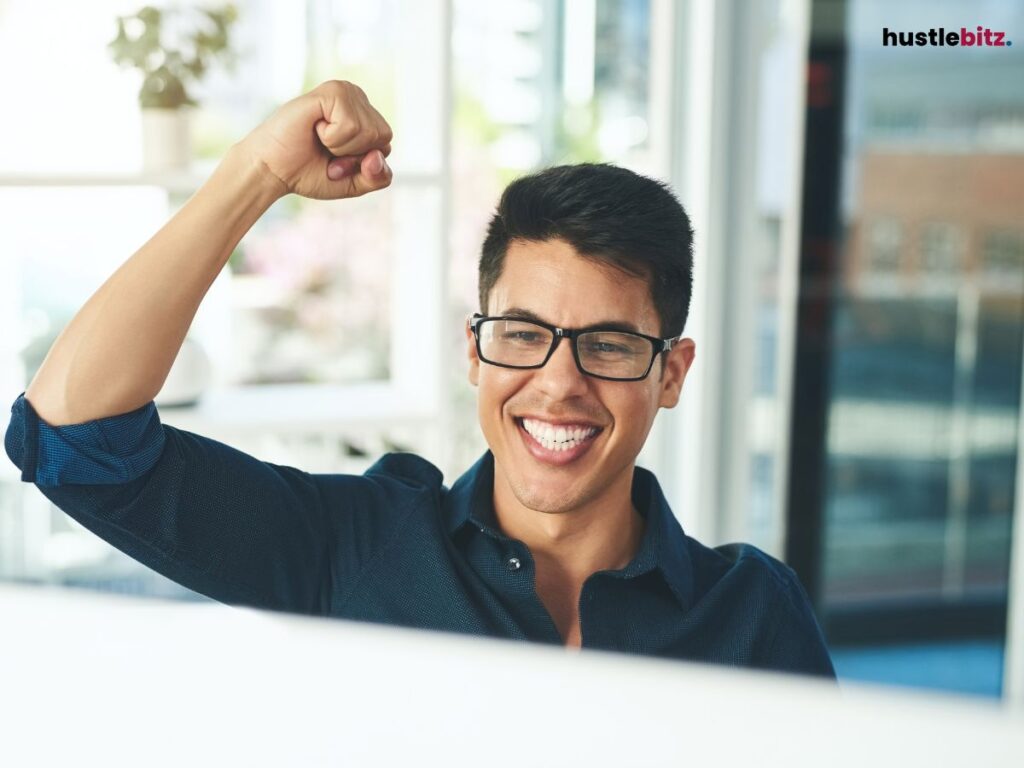 Smiling man raising a fist in success.